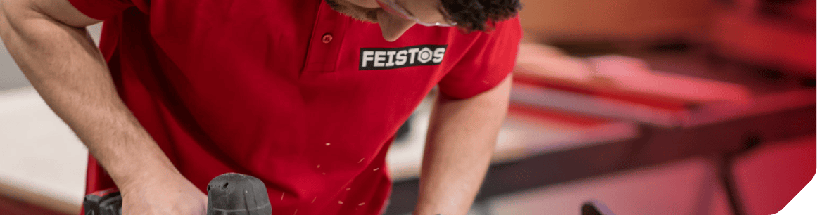 Handwerker in rotem FEISTOS Shirt arbeitet in der Werkstatt